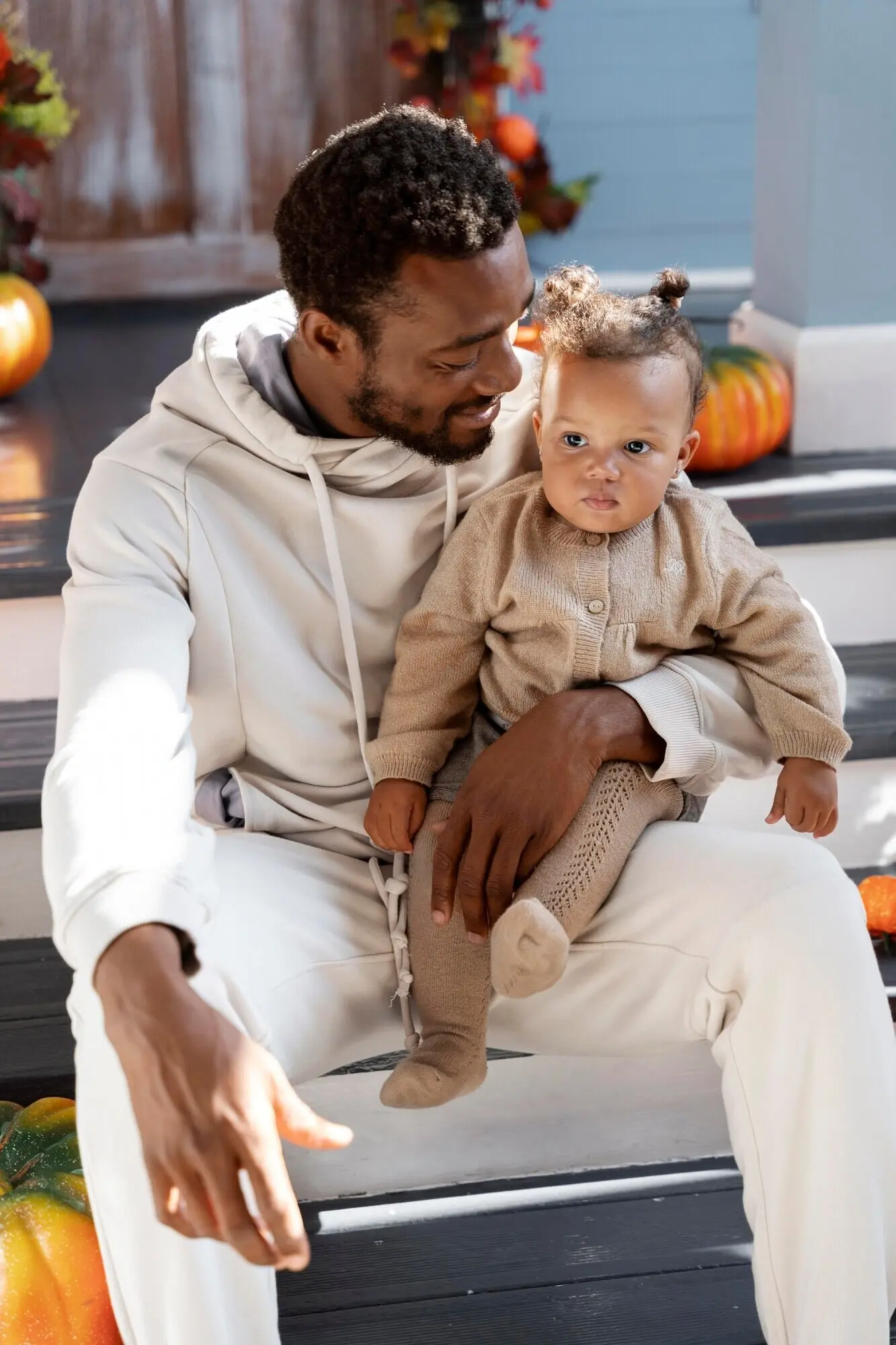 In halbnaher Einstellung hält ein Mann ein Kind.